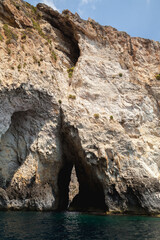 Vertical coastal landscape with narrow dark cave