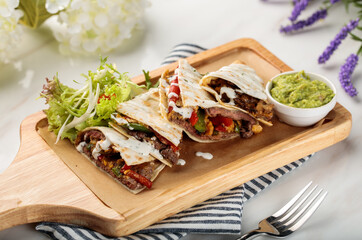 LE SPECIAL Shawarma wraps with salad and sauce served in a cutting board isolated on table side view of arabian food