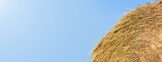 Haystack against the blue sky, close-up. Harvest concept. Rural scenery. Banner