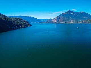Fototapeta premium Aerial view of Lake Como. city ​​center. A local ferry arrives in the city. Bell tower. Tourism and romance. Mountains around the lake. Red roofs. Green Planet. Sailing yacht. Italy, Bellano, 10.2022
