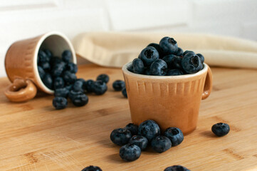 Berries of fresh blueberries in a cup. Coffee cups. Selective focus.