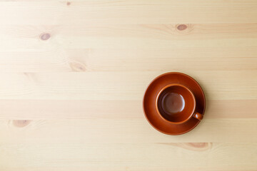 An empty brown coffee cup stands on the table. Space for text. View from above..