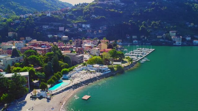 Aerial view of the pool and beach of Lake Como. Vacation in italy in the alps near the water. Tourism and romance. Mountains around the lake. Red roofs. Green Planet. . Italy, Bellano, 09.2022