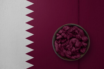 Wooden basket on background in colors of national flag. Photography and marketing digital backdrop. Qatar