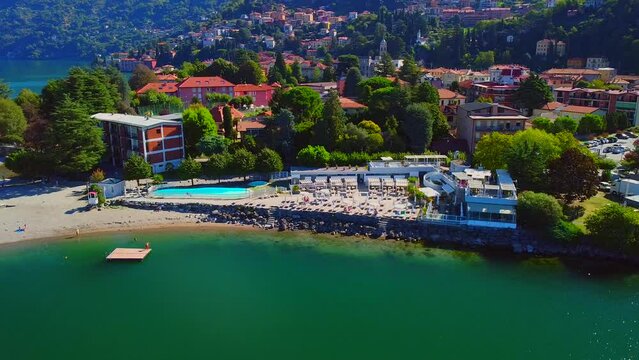 Aerial view of the pool and beach of Lake Como. Vacation in italy in the alps near the water. Tourism and romance. Mountains around the lake. Red roofs. Green Planet. . Italy, Bellano, 09.2022