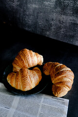 Delicious breakfast with fresh and baked french croissants on a dark concrete background