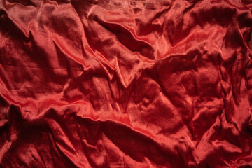 Photo of the texture of a red silk fabric. Red three-dimensional background. The texture of the red...