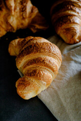 Delicious breakfast with fresh and baked french croissants on a dark concrete background