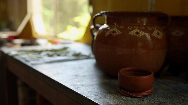 Hand made ceramic pots with indigenous pattern on a wood table with back lighting from a window