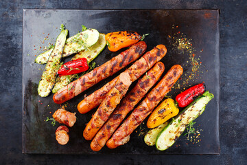Traditional barbecue Bernese sausage with grilled vegetables served as top view on an old rustic...