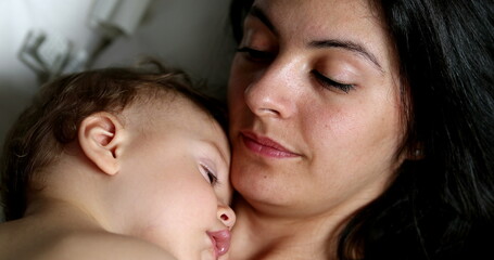 Casual candid mother and baby together napping. Mom and infant asleep