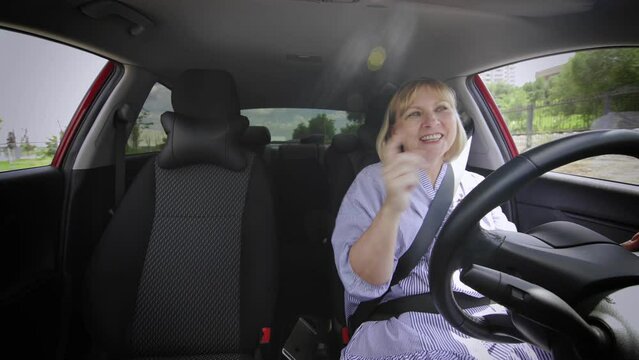 An adult woman sings songs while driving a car