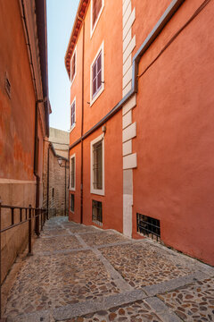 Narrow streets of the old city of Toledo with painted red walls