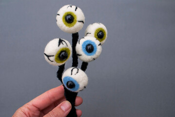 Felted eyeballs with pupils of different colors with a bead in the middle, on a black shaggy wire...