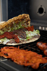 top view of Mexican food Tlayuda de cecina y chorizo and its preparation ingredients on a wooden table, frijoles, beans, cecina, sausage, lettuce, sauce, fruit water