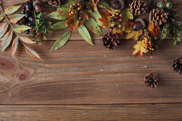 colorful autumn leaves and pine cones on rustic wooden background
