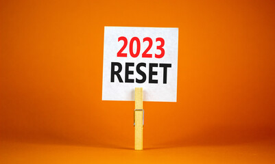2023 Reset symbol. White paper with words 2023 Reset, clip on wooden clothespin. Beautiful orange...
