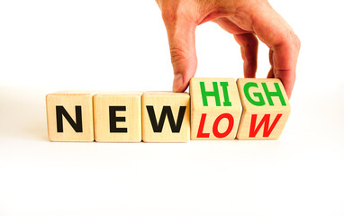 New low or high symbol. Concept words New high and New low on wooden cubes. Businessman hand. Beautiful white table white background. Business new low or high concept. Copy space.