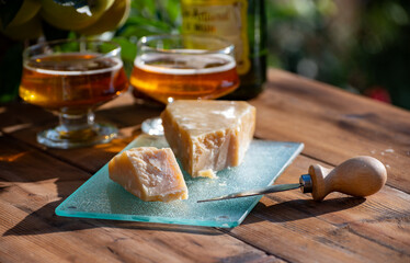 Cheese pairing with drinks,  parmigiano reggiano or parmesan cheese and French apple cider served outdoor