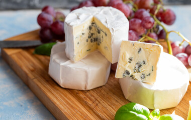 delicious blue brie blue cheese with grapes  on a wooden board