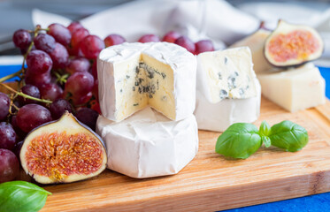 delicious blue brie blue cheese with grapes and figs on a wooden board