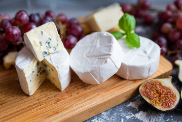 delicious blue brie blue cheese with grapes and figs on a wooden board