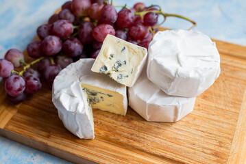 delicious blue brie blue cheese with grapes  on a wooden board
