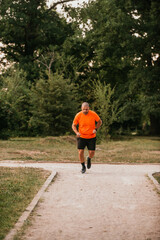 Athletic young man running in nature. Healthy lifestyle