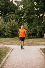 Obraz premium Athletic young man running in nature. Healthy lifestyle