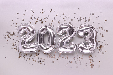 2023 silver balloons and stars confetti. Monochrome New Year's composition.
