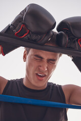 Fitness, tired and injured boxing man in workout, training or exercise at wellness gym. Face,...