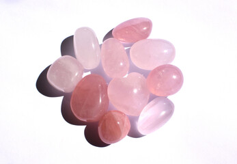 Lots of polished round rose quartz stones. Heart-shaped rose quartz crystals. Semi-precious minerals - a love talisman for women.