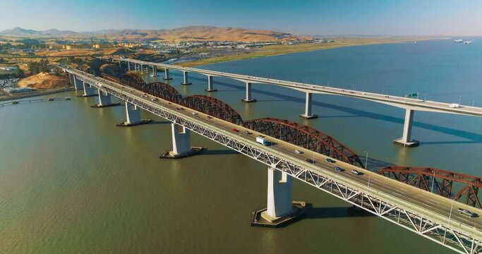 Bridges connecting Martinez to Benicia with transport moving by. Beautiful panorama of the strait and rocky landscape of Martinez, California on sunny daytime.