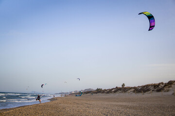 Kitesurfing Athlete Waving His Kite in the Wind on the Shore of a Beach. Concept of Learn...