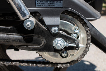 Detail of a motorcycle wheel, swingarm, sprocket and rear drive chain transmitting engine power