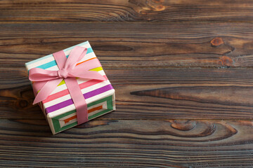 wrapped Christmas or other holiday handmade gift box in color paper with ribbon on colored...