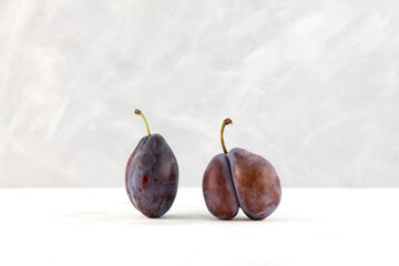 Two plums, normal and ugly fruit. Deformed Fused prune. Double fruit. Food waste reduction. Using...