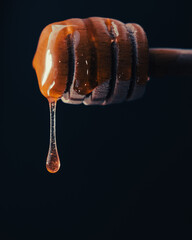 Amber honey dripping on black background