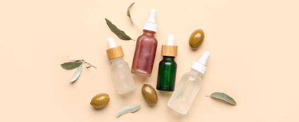 Bottles of essential olive oil on beige background