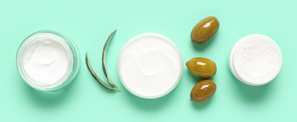 Jars of natural olive cream on turquoise background