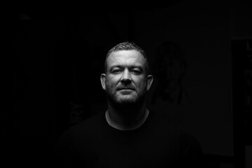 Male alone and looking into the camera with a blank stare.