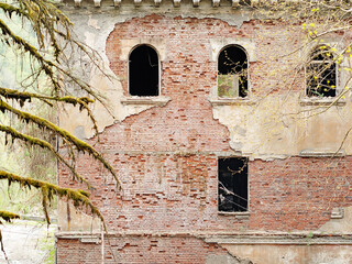 Fototapeta premium Old abandoned building with arched windows. View outside. Empty windows of an old abandoned building