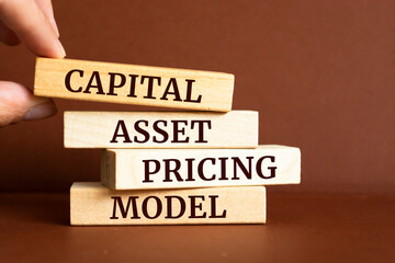 Wooden blocks with words 'Capital Asset Pricing Model'. CAPM