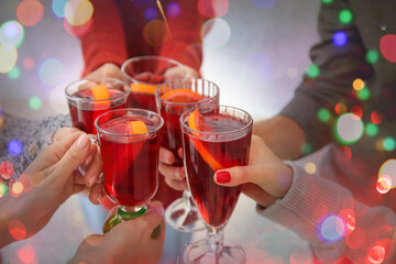 Friends drinking delicious mulled wine at party, closeup