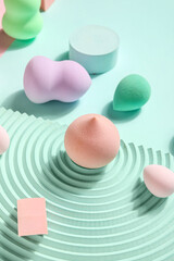 Makeup sponges with decor on blue background