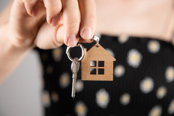 Female hand holding a house keychain.
