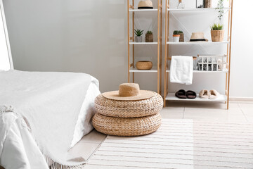 Fototapeta na wymiar Rattan poufs with hat in cozy bedroom
