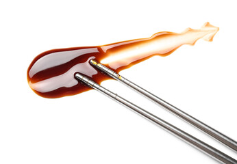 Sample of soy sauce and chopsticks on white background