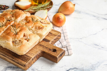 Wooden board with tasty Italian focaccia on light background