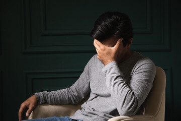 Man sitting from sadness covered his face